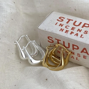 Close-up of S925 hallmark on polished U-shaped silver and gold minimalist hoop earrings