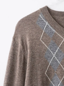 Close-up of brown wool blend sweater with grey argyle pattern and ribbed crew neck detail