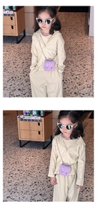 Mini sac bandoulière violet pour enfant avec poignée et chaîne porté par un modèle