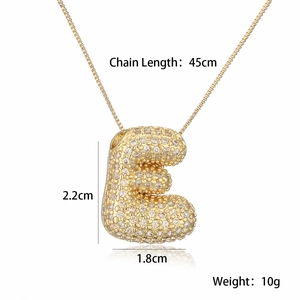 Macro shot of 18K gold plated puffy letter E pendant necklace with clear zircon stones