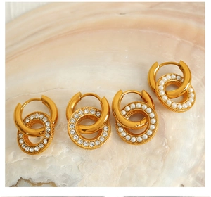 Detailed shot of gold-plated hoop earrings with white pearls and sparkling rhinestones