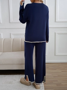 Rear view of dark blue knit lounge set featuring beige trim and side-slit wide-leg pants