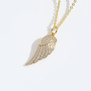Close-up of a gold angel wing pendant necklace with sparkling inlaid rhinestones