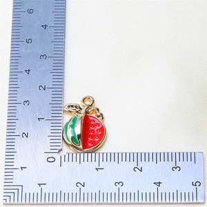 Detailed macro view of a 1.5cm alloy fruit pendant measured against a metal ruler