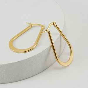 Minimalist 18K gold plated stainless steel U-shaped hoop earrings on white stone base