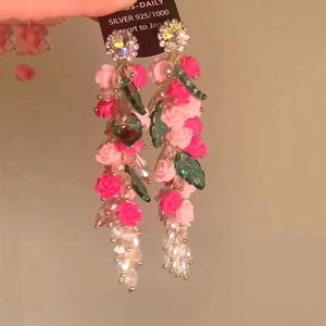 Detail of floral resin earrings with long beaded tassels and sparkling rhinestone studs