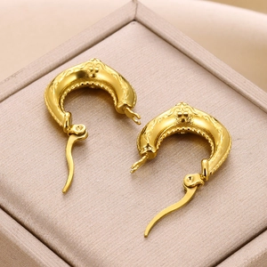 Macro shot of 18K gold plated hollow earrings with vintage embossed texture and hinged clasp