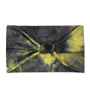 Detail of wide tie-dye knot headband with black, grey, and yellow elastic fabric patterns
