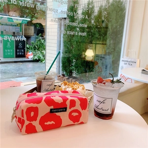 Pink leopard print pencil case with gold zipper detail on a bright cafe table