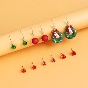 Macro detail of Christmas earrings set featuring festive red and green crystal designs