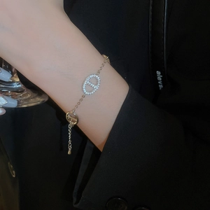 Detail showing gold plated oval link bracelet with cubic zirconia on model's wrist