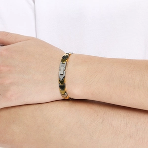 Detailed view of tri-color metal bracelet in gold, silver, and black on a male wrist