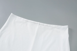 Macro detail of the high-elasticity ribbed knit texture and fine stitching of the white set