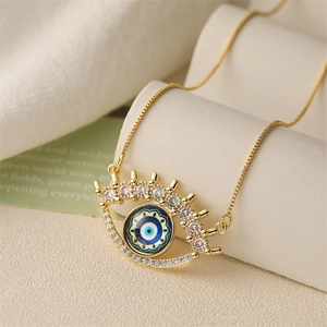 Detailed macro view of gold evil eye pendant with blue inlay and sparkling zircons