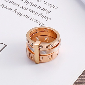 Close-up of rose gold hollow ring with roman numerals and shell inlay on book page