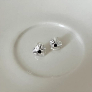 Elegant 925 sterling silver heart stud earrings with black zirconia on a white plate