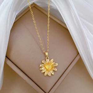 Detail of champagne gold flower necklace with yellow heart gemstone in a jewelry box