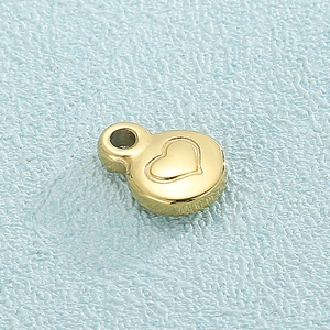 Golden heart-shaped stainless steel pendant with embossed pattern on blue background
