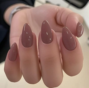Gros plan d'ongles artificiels brillants en forme d'amande de couleur vieux rose