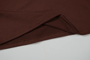 Close-up of double-needle stitching on the hem of a dark brown knitted maxi dress