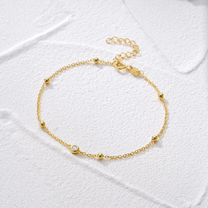 Detailed macro view of gold S925 sterling silver beaded bracelet with sparkling zircon