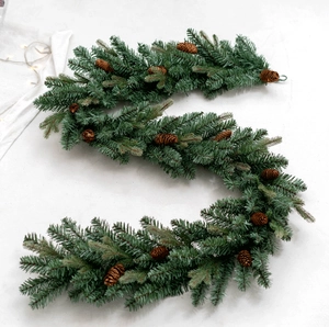 Close-up of premium PE mixed Christmas garland with pine cones and festive warm LED lights