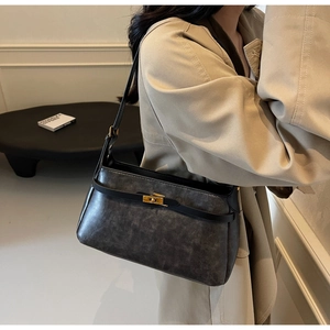 Dettaglio della borsa a spalla vintage grigio-nera con chiusura dorata e profili in pelle