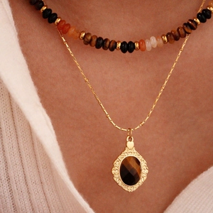 French vintage tiger eye and black onyx beaded necklace set on white knit sweater