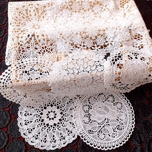 White floral lace coasters and embroidered tablecloth with elegant rose patterns