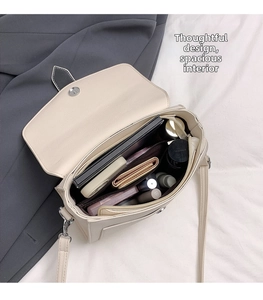 Internal view of the cream crossbody bag showing spacious main compartment and storage