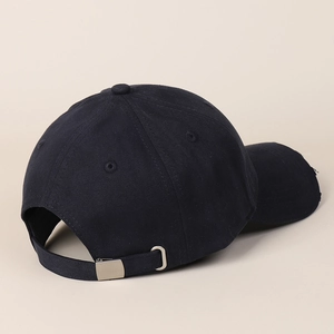 Detail of black baseball cap showing adjustable metal buckle and distressed brim edge