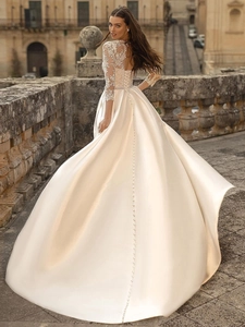 Lace bodice satin wedding dress with long sleeves and elegant lace-up back detail