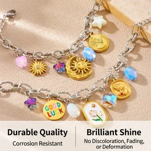 Detail of stainless steel charms featuring tulip, moon, and Good Luck coin on sand