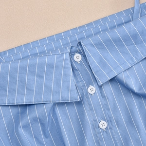 Detailed close-up of vertical blue and white stripes on a collared shirt with white buttons