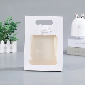 Detail of white gift bag with transparent window and elegant ribbon bow design