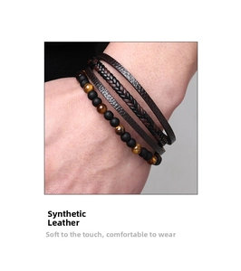 Detail of men's layered leather bracelet with tiger eye beads and matte black stones