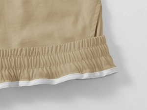 Detail of khaki cargo shorts showing elastic waistband and high-quality stitching