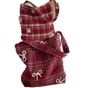Red plaid tweed handbag with decorative white 3D bows shown on a white background