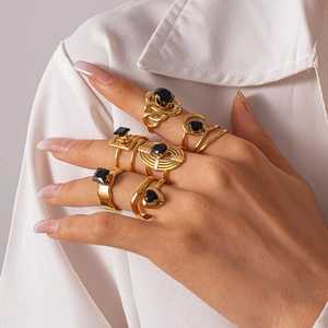 Ensemble de bagues dorées double couche serties de zircons noirs sur la main