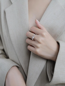 Close-up of elegant moissanite bow ring in silver on finger with a minimalist style