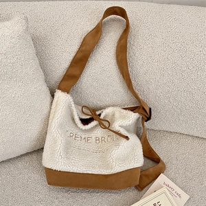 Détail du sac cabas en laine d'agneau crème avec surpiqûres marron et broderie chic