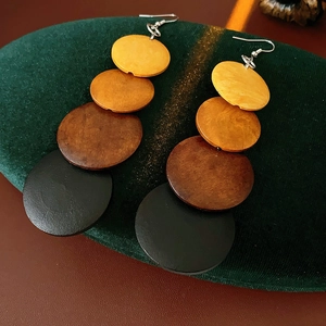 Detailed view of bohemian layered round wood bead earrings with color gradient effect
