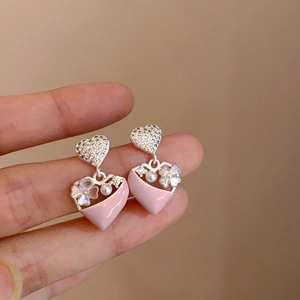Dettaglio di orecchini a cuore rosa con perle e cristalli su perni in argento 925