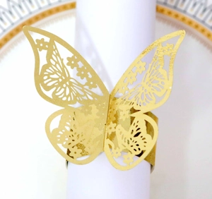 Detail showing a golden laser-cut butterfly napkin ring on a white napkin roll