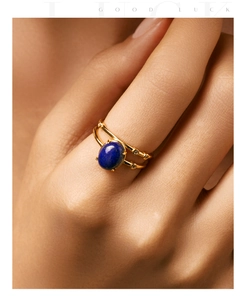 Detailed close-up of an 18K gold ring with oval lapis lazuli and pavé diamonds