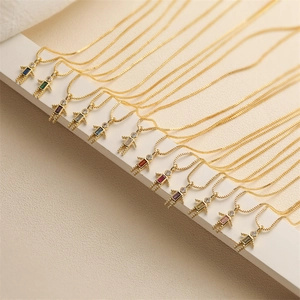 Detailed view of gold box chain necklaces with colorful zircon robot boy pendants