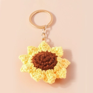 Handmade crochet sunflower keychain with yellow petals and gold metal ring on pink base
