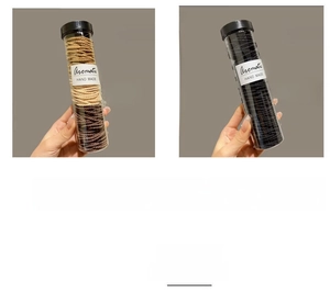Detailed view of coffee and black seamless woven hair ties in clear cylinder packaging