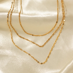 Elegant 18K gold plated triple layered stainless steel necklace on champagne silk