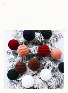 Detail of 10cm red flocked Christmas ball with wave texture on snowy tree branch